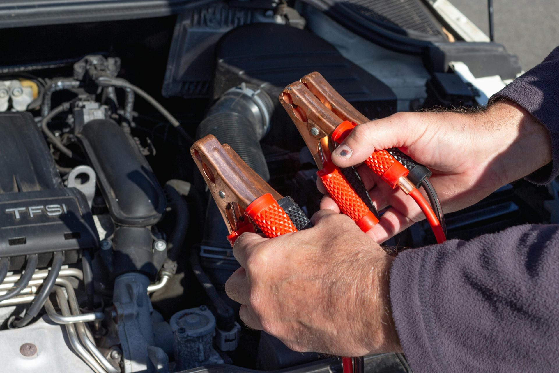 Manos con saltadores al lado de un motor